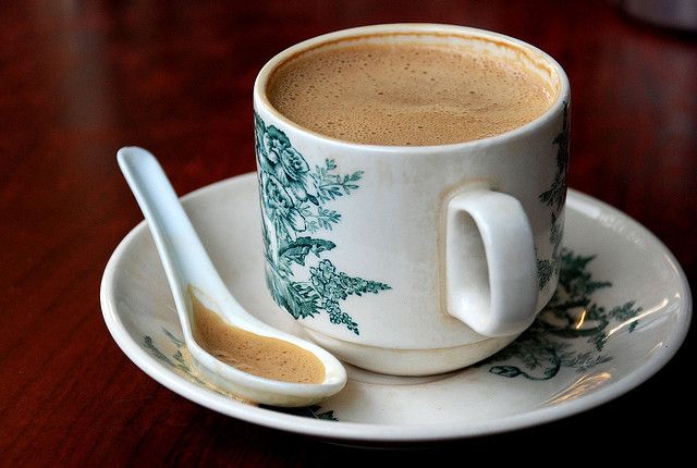 Cup of Malaysian white coffee with ceramic spoon