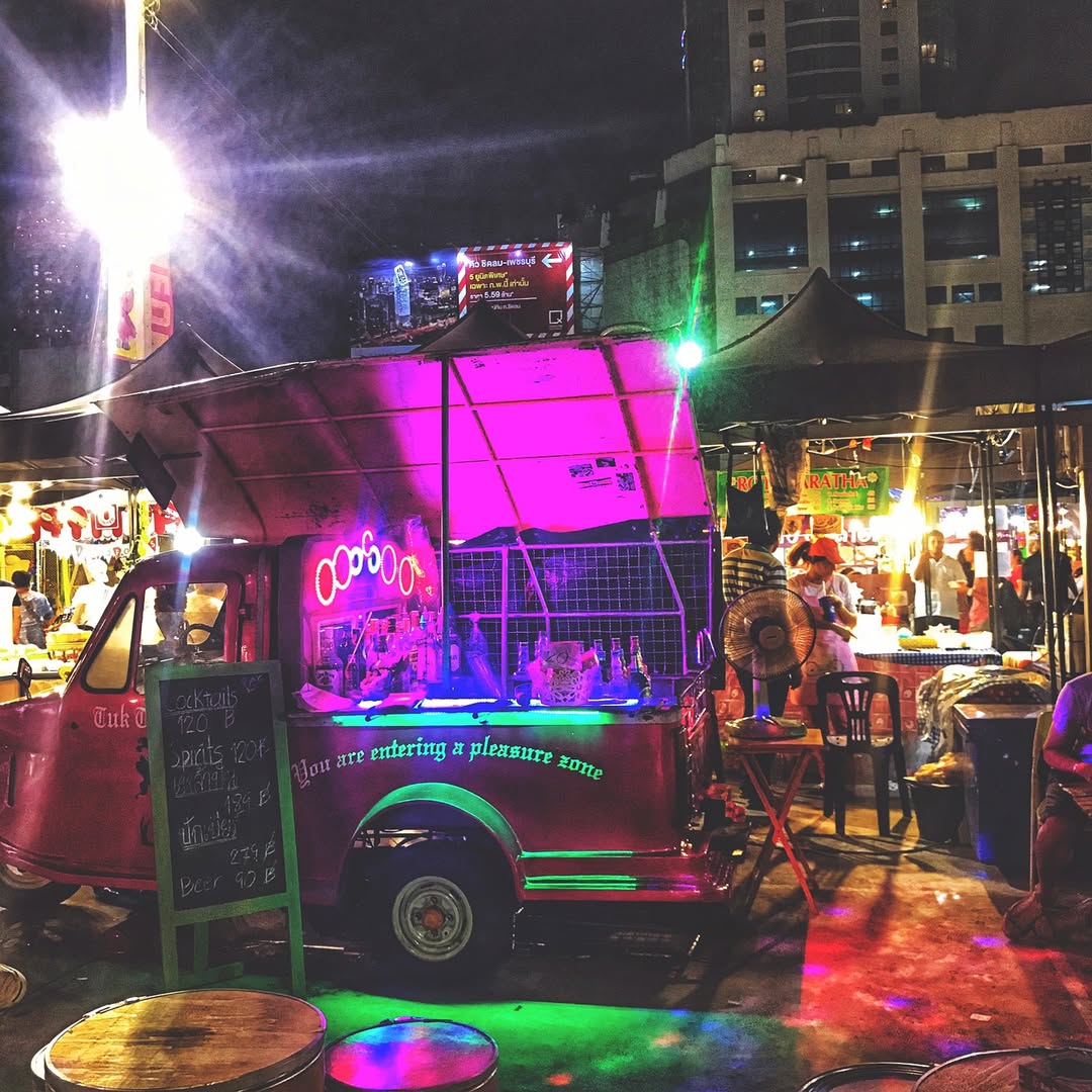 Pratunam Night Market in Bangkok with colorful neon lights and busy evening crowd