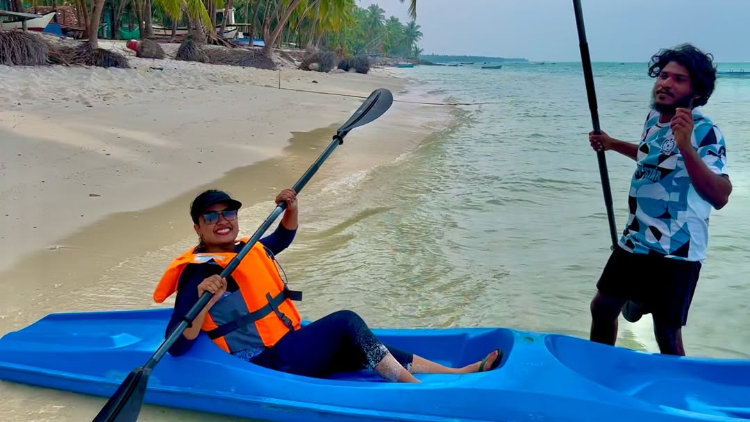 Woman paddling a kayak on Lakshadweep beach with clear turquoise water